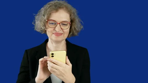 Business woman in suit using mobile phone on blue chromakey, small business e Видео 163544553