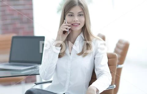 Business woman talking on mobile phone sitting in the office Stock Photos