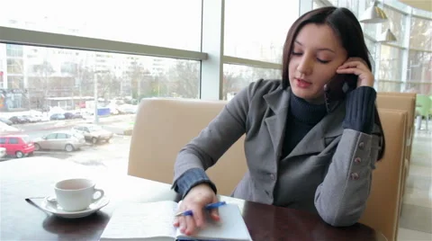 Business woman talking on smart phone and writes in notebook Stock Footage 59778901