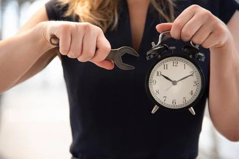Business woman try to adjust time on alarm clock after shocked with late i... Stock Photos