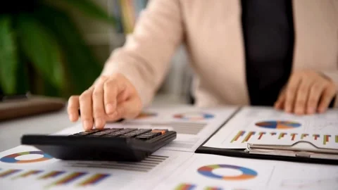 Business woman using calculator while analyzing data reports in office Stock-Footage 335955814