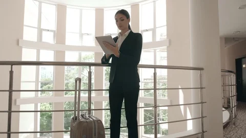 Business woman using her digital tablet and looking on it while sitting on bed Stock Footage