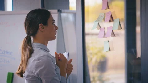 Business woman using sticky notes brainstorming problem solving strategy on glas Stock Footage