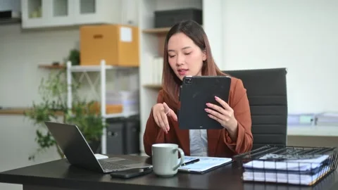 Business woman using tablet and laptop for doing math finance on an office .. Stock Footage 313265755