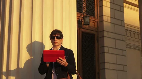 Business woman using a tablet computer in front of a building Stock Footage 32502999