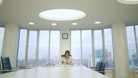 Business woman working with documents while sitting at the table in a spacious Video stock 105354372