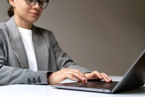 Business woman working on her laptop while sitting at desk. Stock Photos