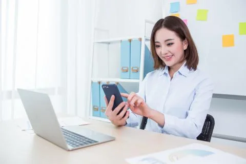 Business woman working at office and using smart phone Stock Photos