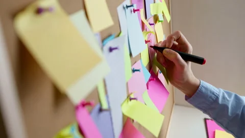 Business woman's hand writes down a note post on a paper sheet. Video stock 238776654
