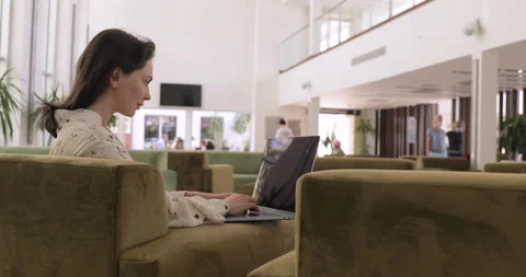 Businesslady working on computer in restaurant. Sitting in chair with notebook  Stock Footage 154336089