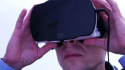 Businessman adjusting a VR-headset - 4 K Stock Footage 71214064