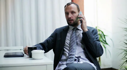 Businessman after work talking on the cellphone at home. Stockbeeldmateriaal 36708352