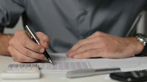 Businessman analyzes financial graphs: Doing calculations at the office 스톡 동영상 33880047