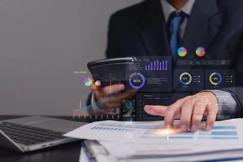 Businessman analyzing data and using a calculator with futuristic holograph.. Stock Photos