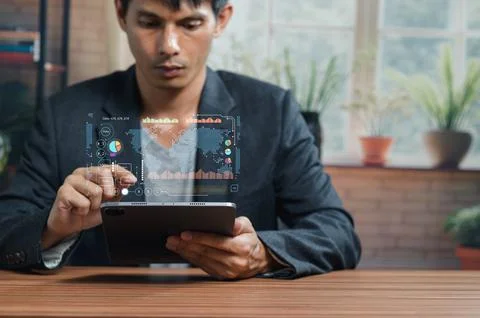 Businessman Analyzing Data with Digital Charts on Tablet Device Stock Photos