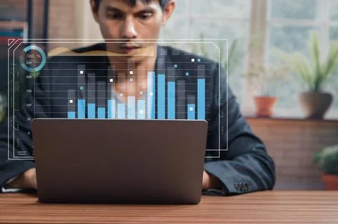 Businessman Analyzing Data Trends on Laptop with Charts Displayed 스톡 사진