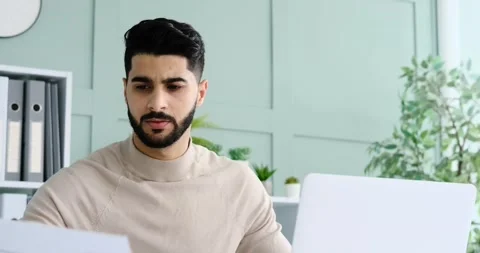 Businessman analyzing document and using laptop at office Stock Footage 195508602