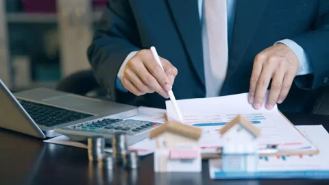 Businessman analyzing financial charts, counting coins, and using a calcula.. Video stock 345940945