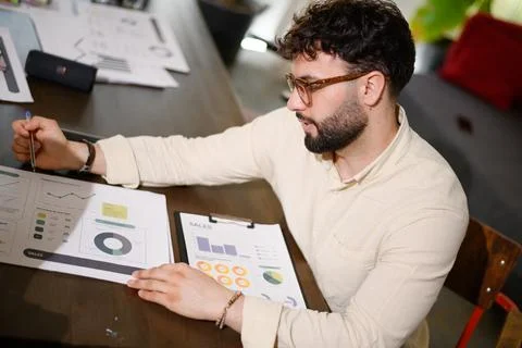 Businessman analyzing sales data during a strategy meeting in a modern office Stock Photos