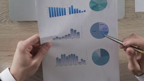 Businessman analyzing statistical graphs and putting data to laptop, reports Stock Footage 76762153