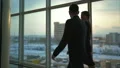 The businessman and a businesswoman walking along the window. slow motion 4k or 4k+ Resolution