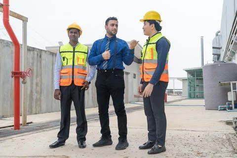 Businessman and engineer talking while walking at construction site. 스톡 사진