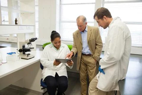 Businessman and scientists using digital tablet in laboratory Foto stock