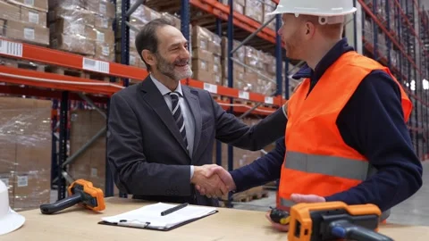 Businessman and warehouse worker shaking hands after successful deal Stock Footage 312856450