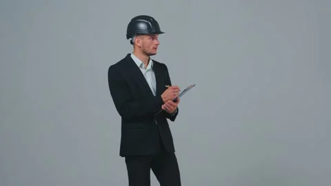 Businessman architect or construction manager in hard hat walking, making notes Stock Footage 220953563