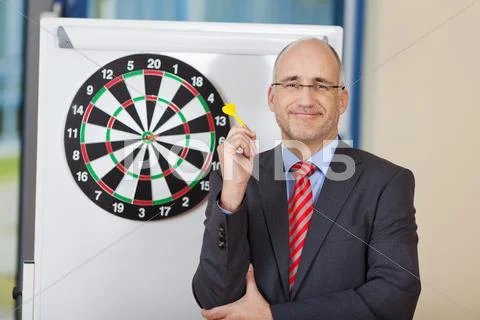 Businessman attaching dart on target Stock Photos