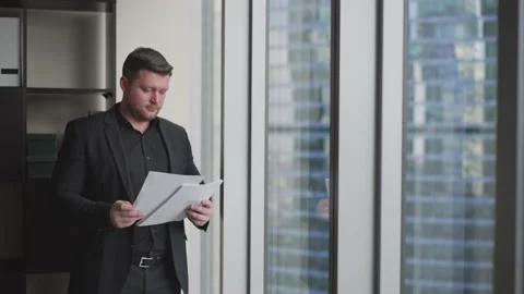 Businessman on the background of a skyscraper with paper documents. Portrait of Stock Footage 173829442