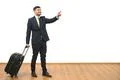 The businessman with a bag gestures on the white wall background Photo