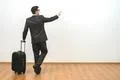 The businessman with a bag gesturing on the white wall background Photo