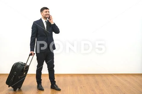 The businessman with a bag phones on the white wall background Stock Photos