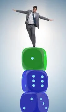 Businessman balancing on top of dice stack in uncertainty concep Stock Photos