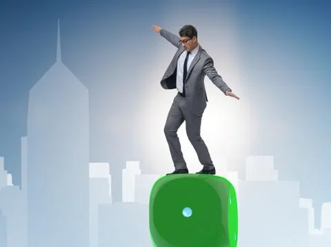 Businessman balancing on top of dice stack in uncertainty concep Stock Photos
