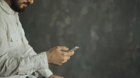 Businessman with a beard and mustache using digital phone against Creative gray Stock Footage 58120148
