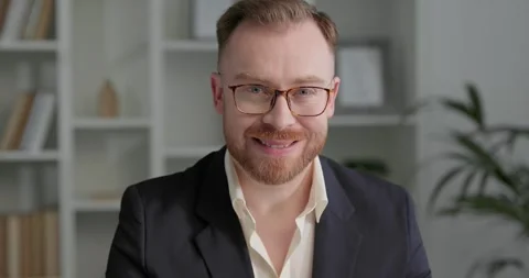 Businessman with beard looking at camera and smiling at his workplace. Stock Footage 249181403