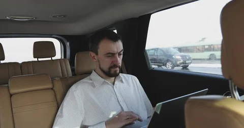 Businessman with a beard working on a laptop while traveling Stock Footage 86092015
