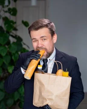 Businessman in black gloves eats bread Stock Photos
