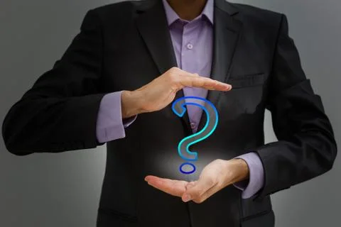 Businessman on blurred background touching hand drawn question marks with his Stock Photos