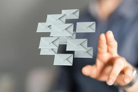 Businessman on a blurry background touching a floating render of email icons Stock Photos