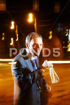 A businessman with a bottle in night street Stock Photos