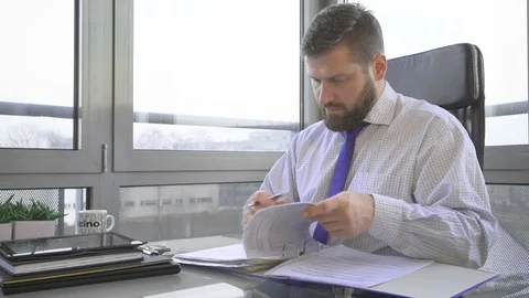 Businessman browsing document, data, in ring binder looking at camera, office Vídeo Stock 73169805