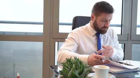 Businessman browsing documents, making notes, ring binder, office, slider shot 库存影片 72500454