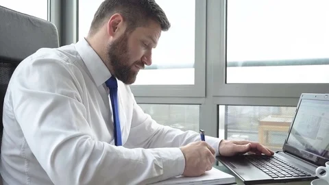 Businessman browsing laptop, taking notes in the office. Slider and pan shot Vidéo 72361508