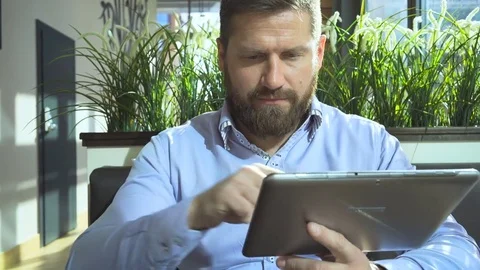 Businessman browsing tablet computer, in cafe, close portrait steadycam shot 库存影片 73316700