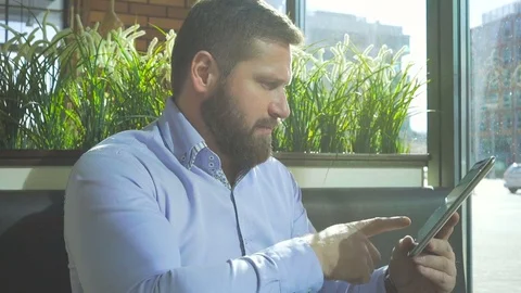 Businessman browsing tablet computer, in cafe, close profile steadycam 库存影片 73316704