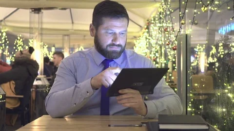 Businessman browsing tablet computer, evening, cafe, portrait, christmas Vidéo 72999731