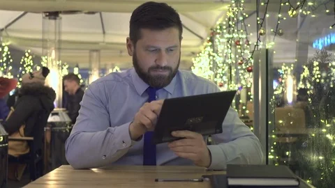 Businessman browsing tablet computer, look at camera, evening, cafe, portrait Stock Footage 72999752